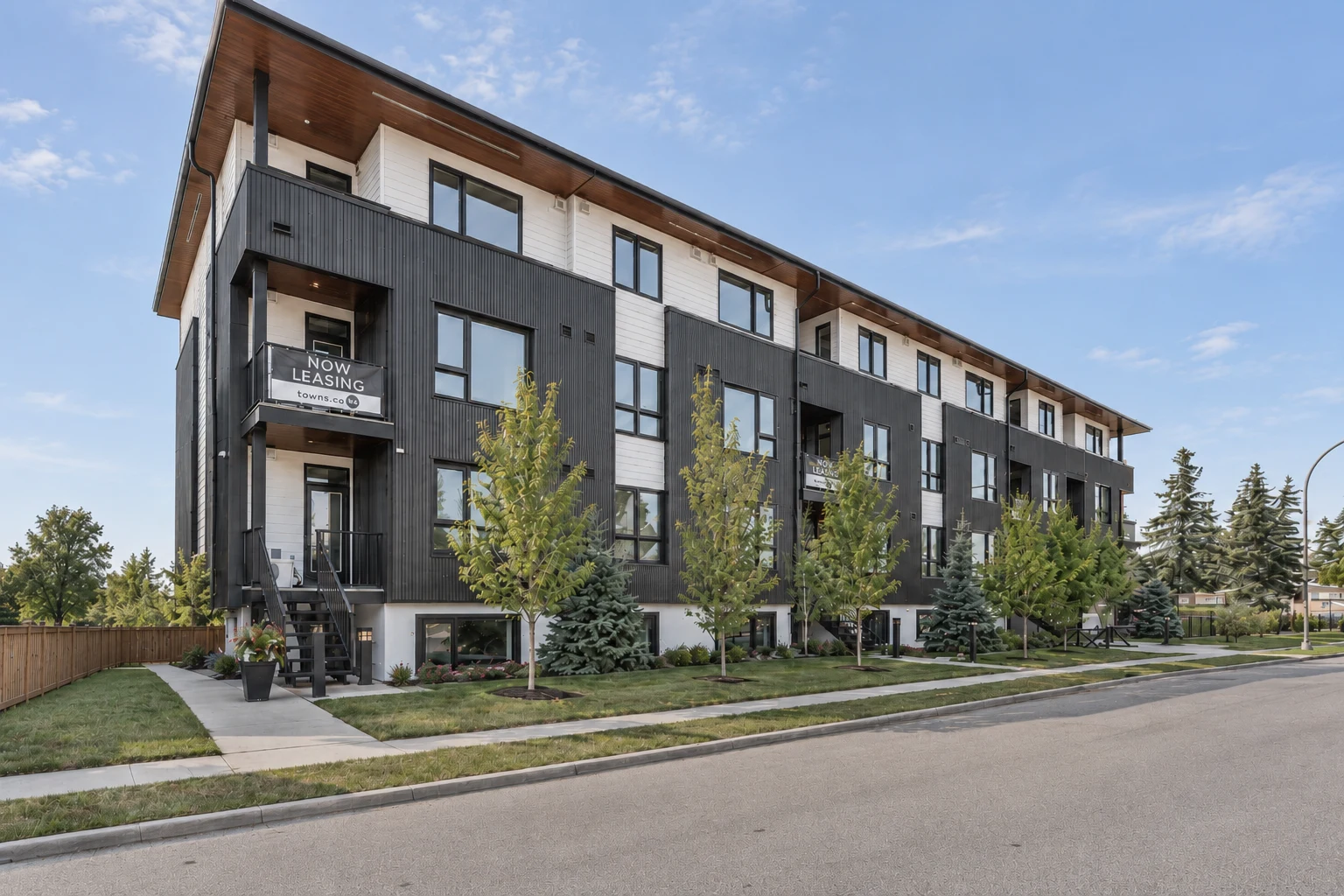 Completed Optima multi-family development at 4616 73 St NW, Calgary, showing the exterior, entrances and landscaping